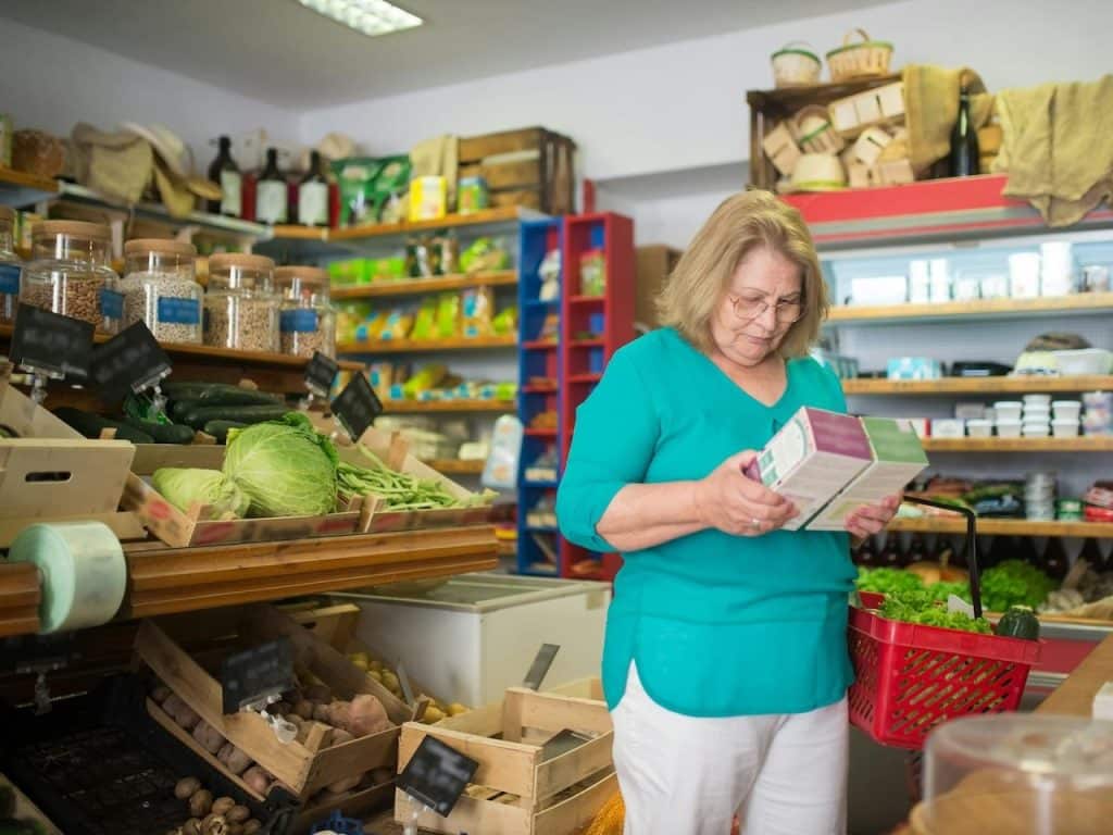 Mujer comprueba el origen de dos alimentos en un supermercado