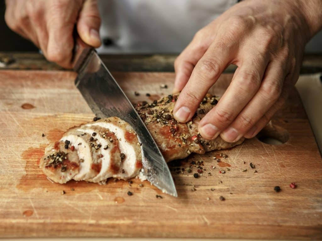 Man cuts meat roll