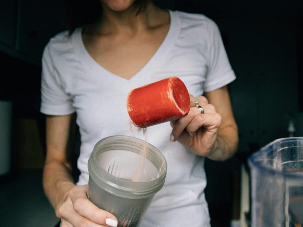 Mujer prepara batido de proteínas