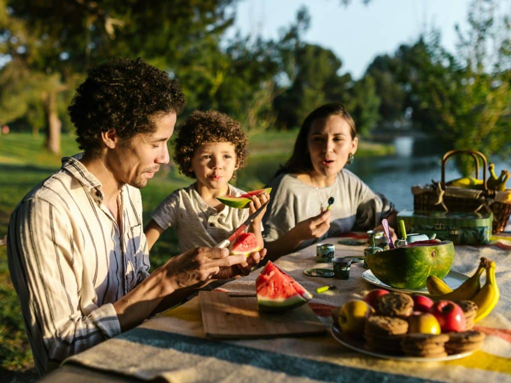 Familia come productos frescos en el campo