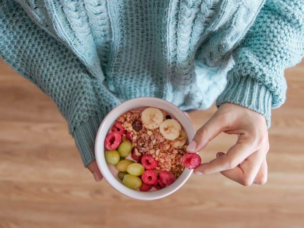 Mujer toma bol de frutas